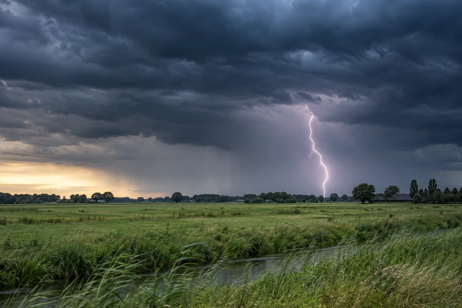 Lightning flashes above distant farmland.